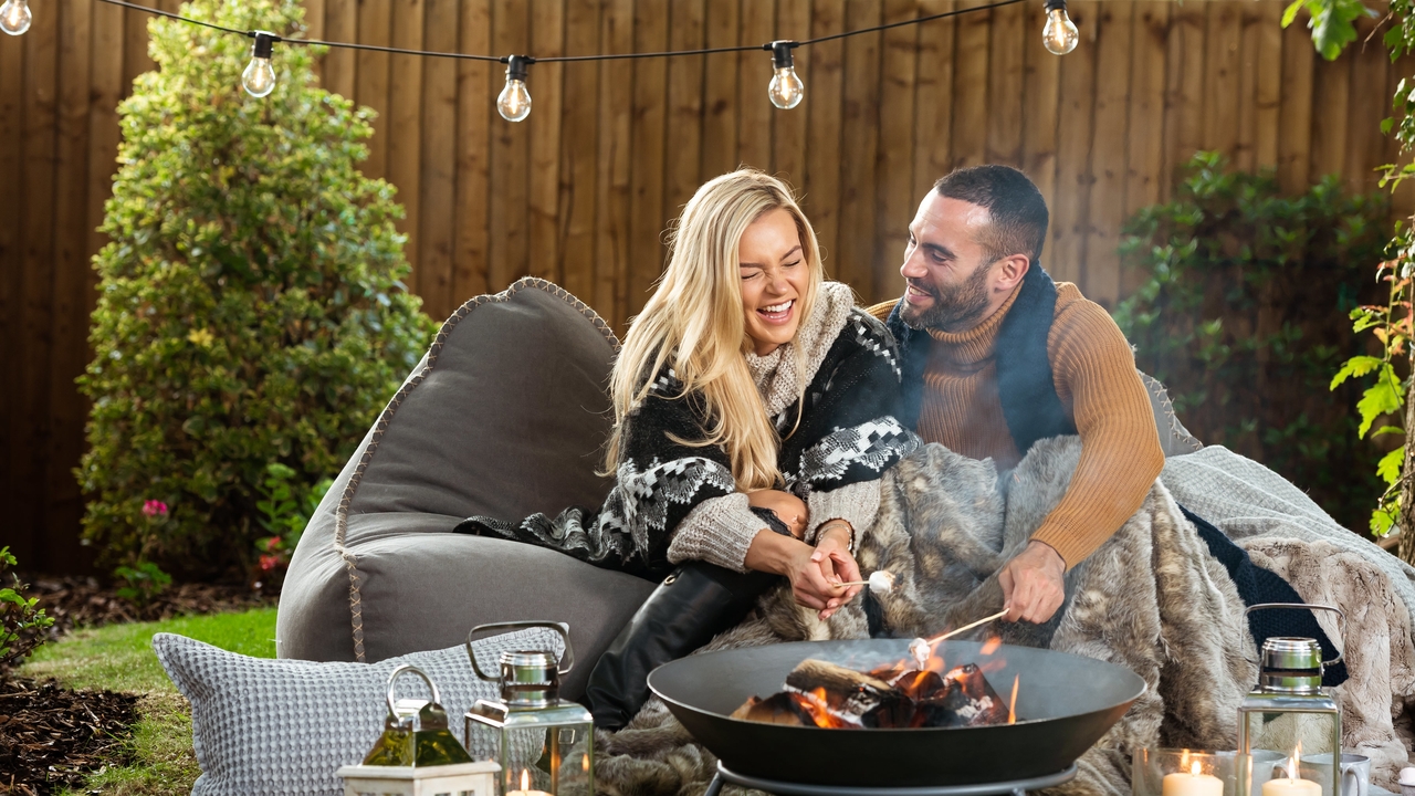 Redrow - Inspiration - A happy young couple sitting on a beanbag under an outdoor light