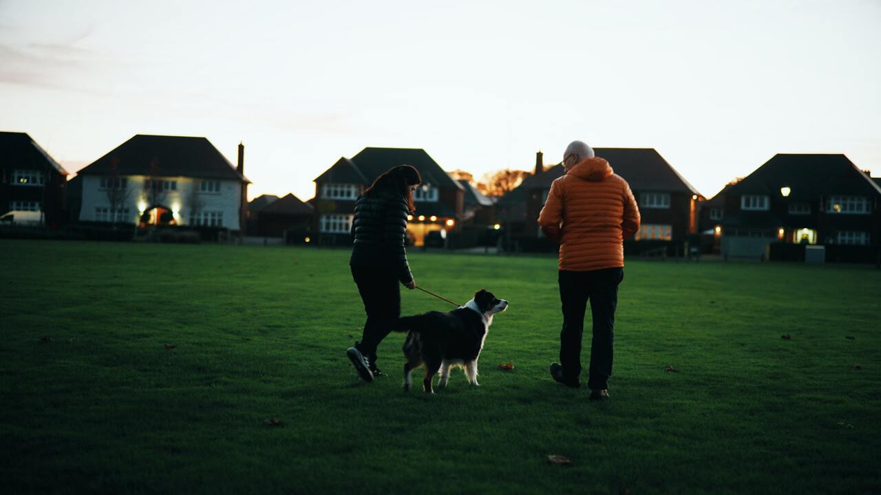 Redrow - Inspiration - Paralympian Menna Fitzpatrick walking her dog on an area of green space