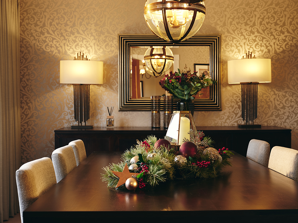 Redrow | Inspiration | A large wooden table decorated with winter bouquets, with a central mirror flanked by lamps in the background