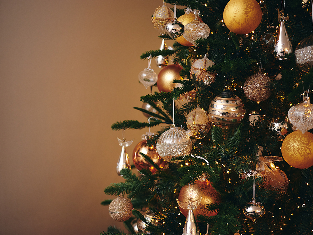 Redrow | Inspiration | A dark green Christmas tree hung with white and gold baubles