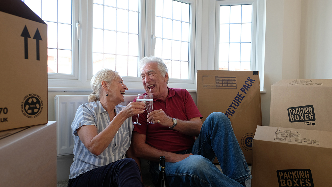 Redrow | Inspiration | man and woman sat on the floor amid their moving boxes